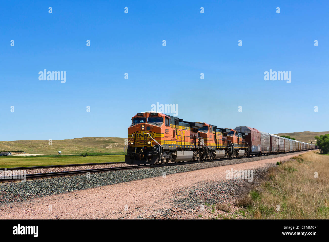 A 2km de largo tren de mercancías en la zona rural de Nebraska, junto con la porción occidental de NE 2, Nebraska, EE.UU. Foto de stock