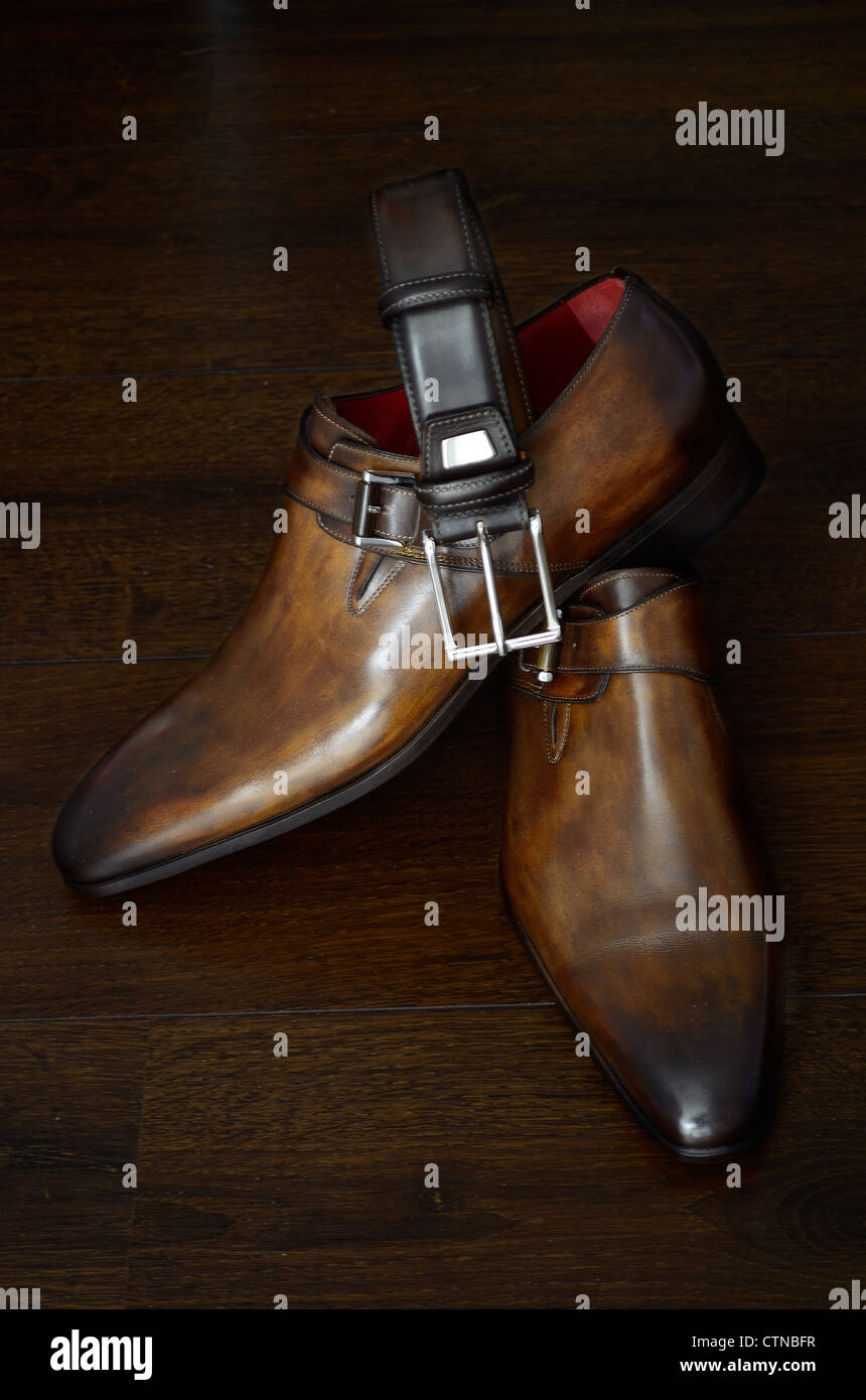 Estilo italiano de lujo zapatos de cuero marrón y correa para él contra un  fondo oscuro Fotografía de stock - Alamy