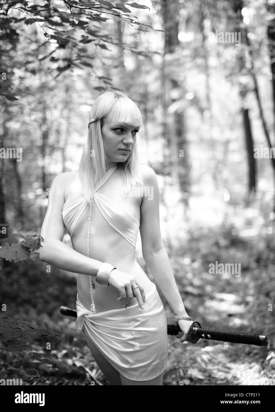 Fantasy mujer rubia con la espada en el bosque Foto de stock