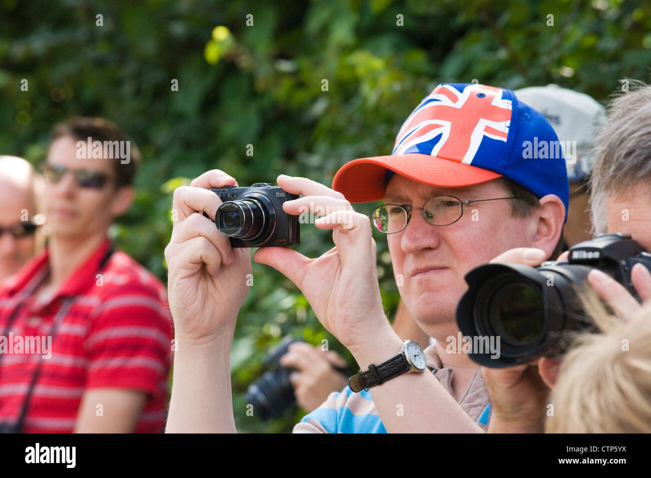 Juegos Olímpicos de Londres 2012. Los espectadores tomando fotografías de hombres del ciclo Road Race en Ripley, Surrey. Foto de stock