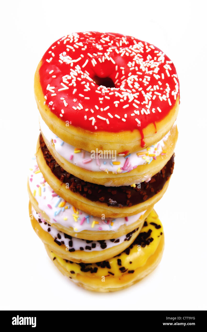 Pila de coloridos y deliciosos donuts sobre un fondo blanco. Foto de stock