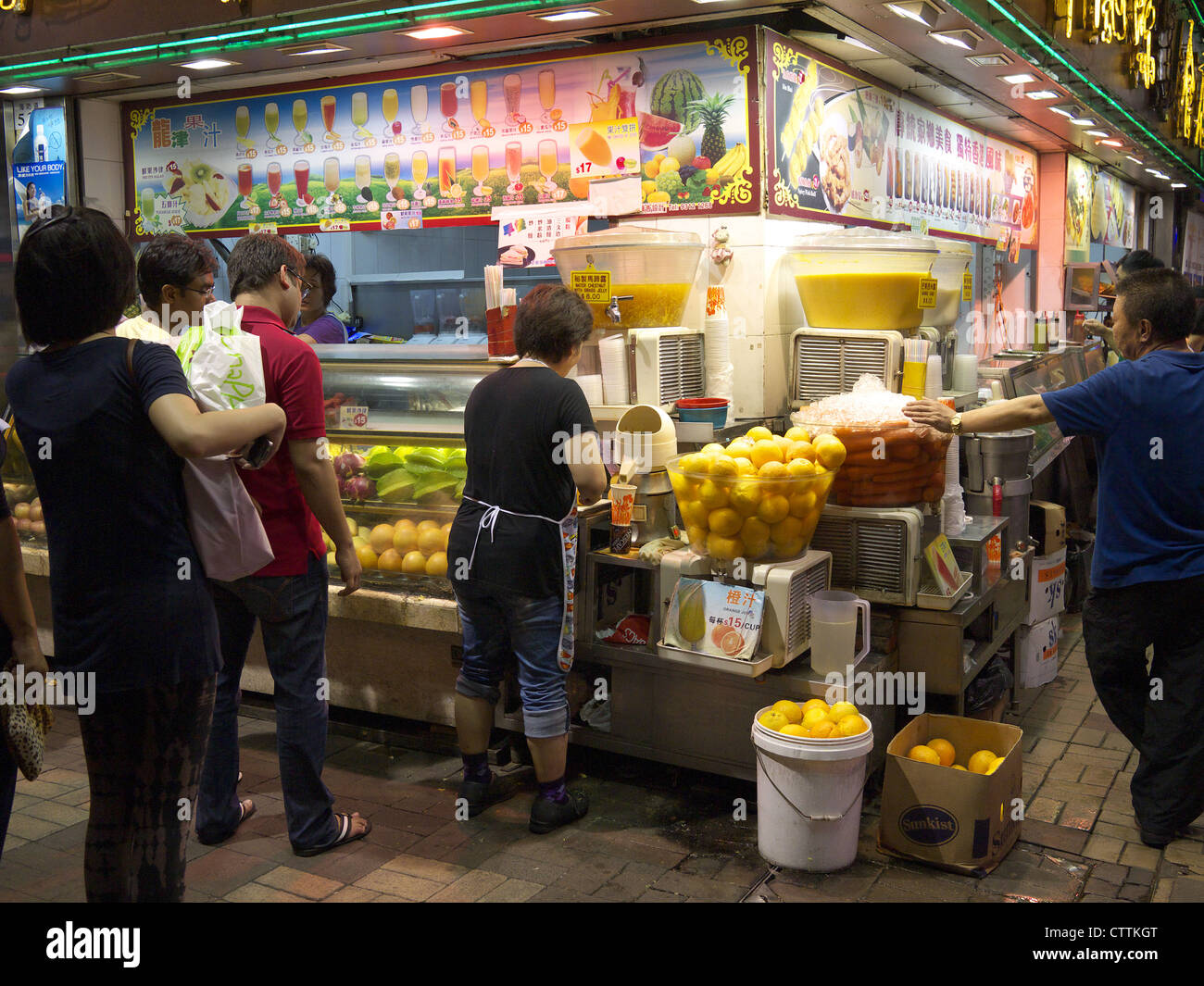 Hong Kong típico quiosco de comida rápida en la calle por la noche, la venta de bebidas de frutas frescas recién exprimidas Foto de stock