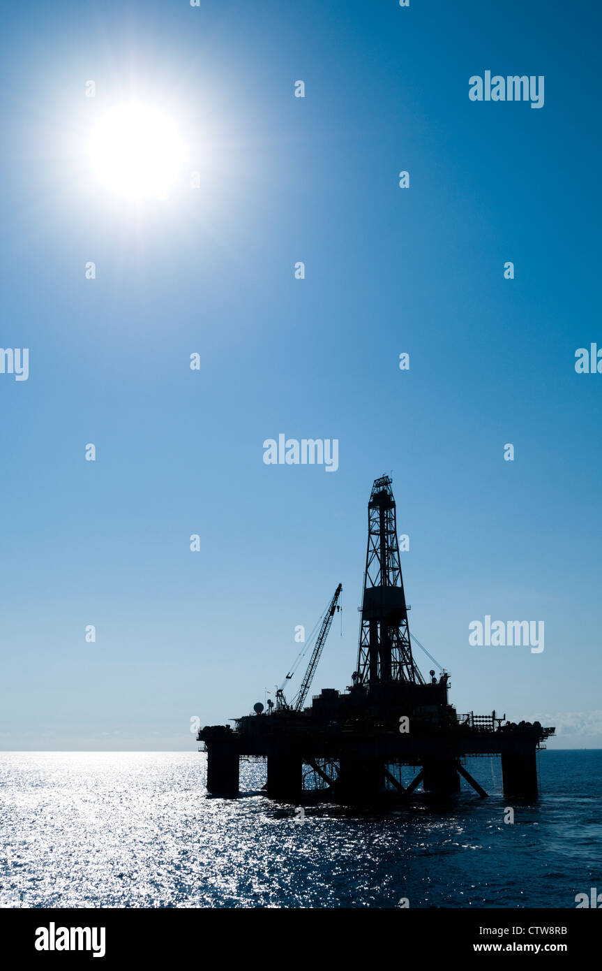 Silueta de una plataforma petrolífera en alta mar en la zona oceánica. Foto de stock