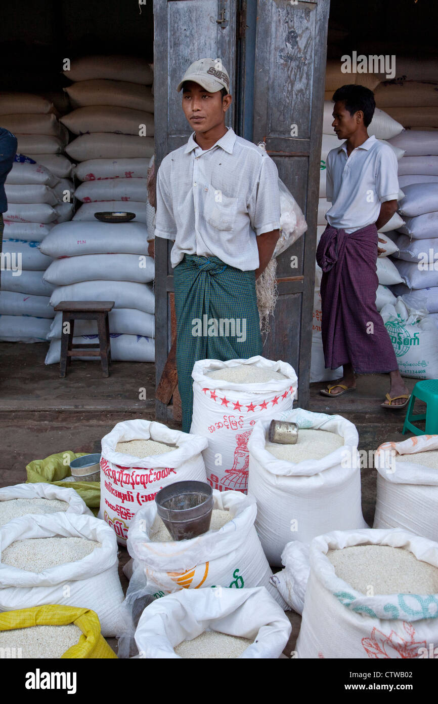 Myanmar, Birmania. Vendedor de arroz, Bagan mercado. Los dos hombres se están desgastando los Birmanos longyis wrap-around sarong. Foto de stock