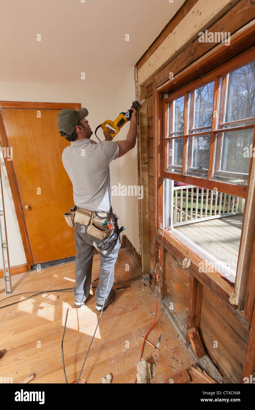 Carpintero hispano con sierra caladora para quitar la ventana y cortar la  puerta de acceso Fotografía de stock - Alamy
