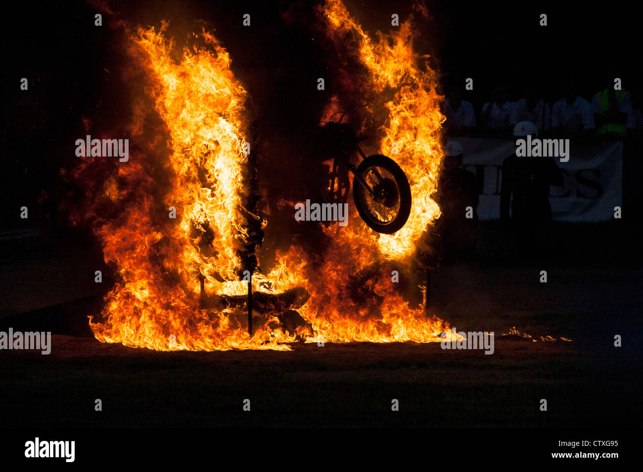Moto rider próximos a través de una pared de fuego Foto de stock