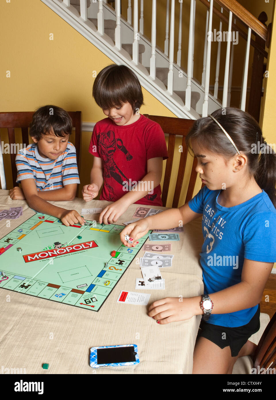 Grupo multiétnico de amigos hispana y asiática jugar juego de mesa Monopoly  en casa durante las vacaciones de verano Fotografía de stock - Alamy