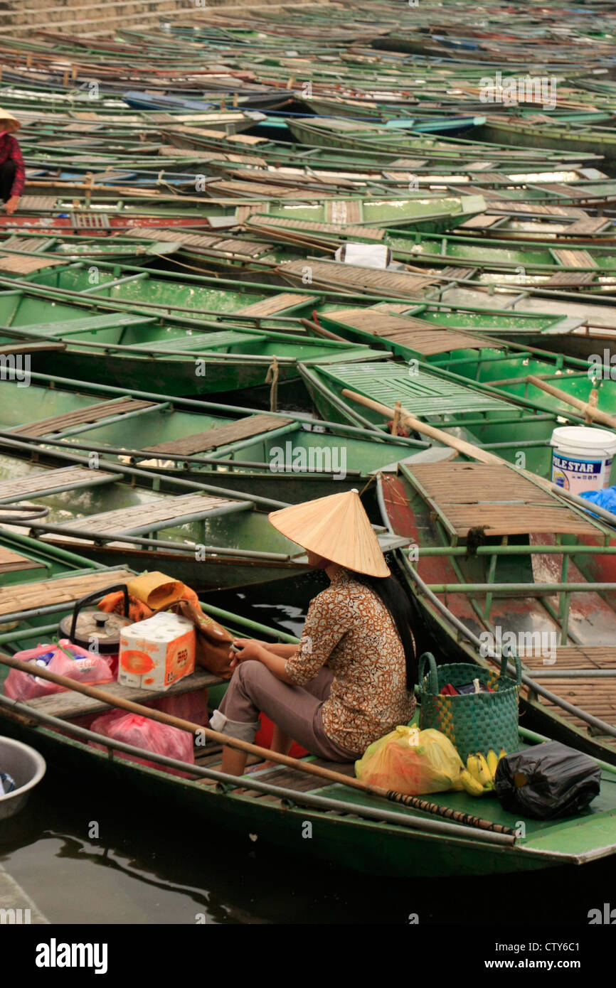 Mujer con sombrero de paja sentado en un barco, Tam Coc, Vietnam Foto de stock