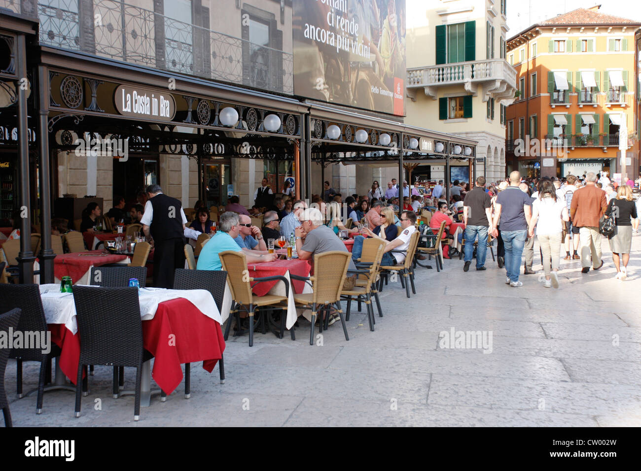 Concurrido restaurante turístico / cafetería en el centro de Verona, junto a la arena en la Piazza Bra,Italia Foto de stock