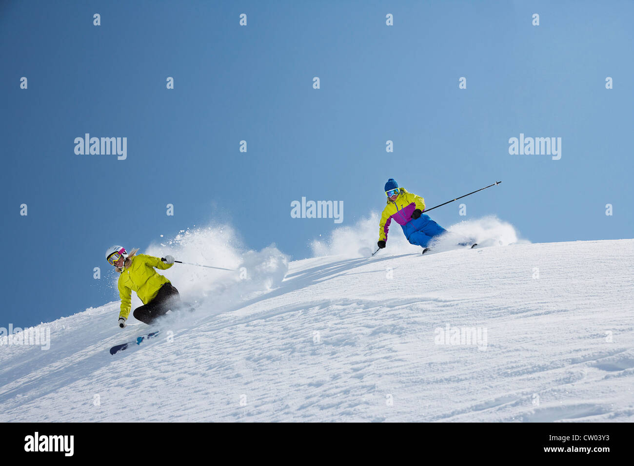 Los esquiadores de cabotaje con nieve pendiente Foto de stock