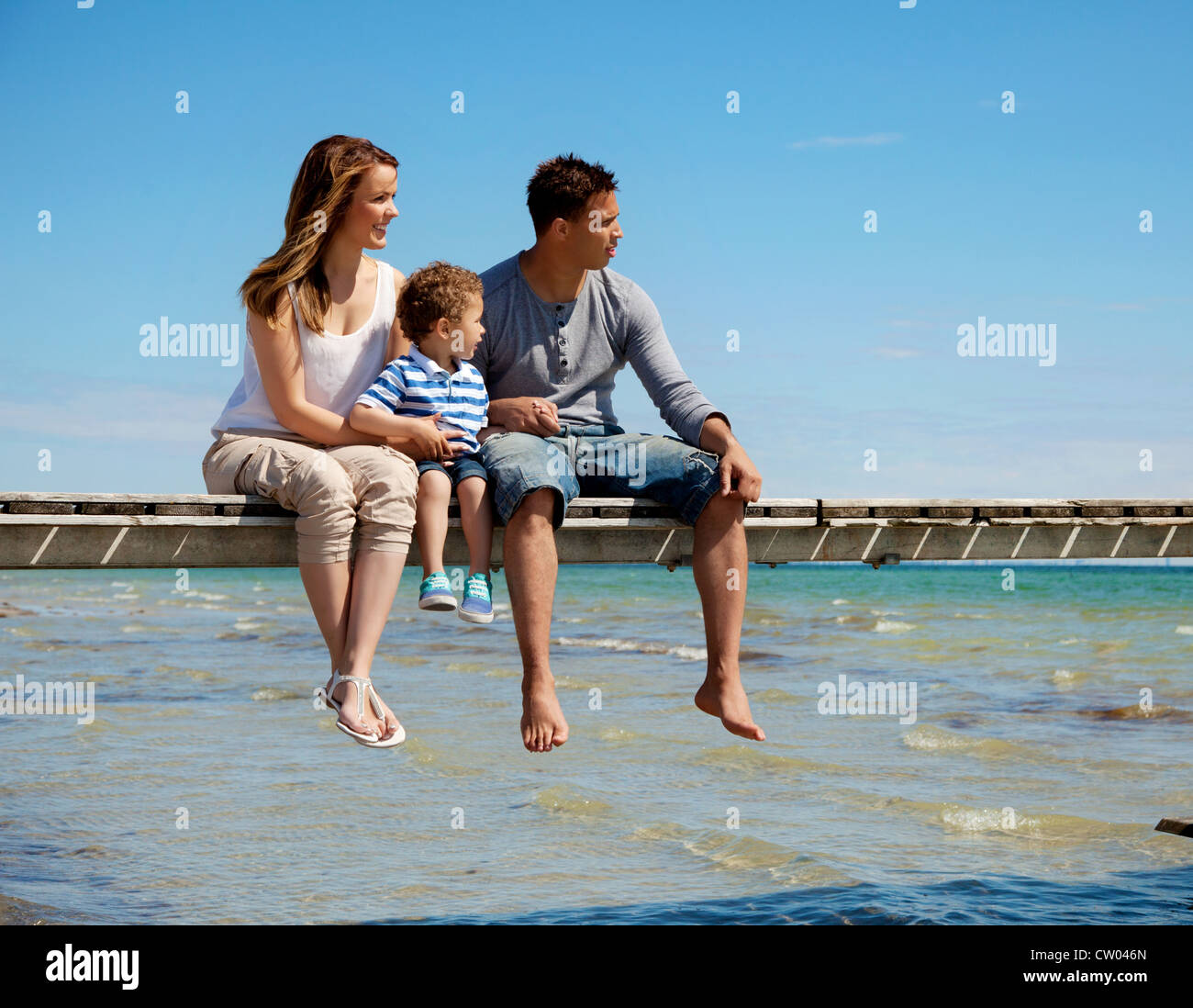 Joven familia disfruta de la hermosa vista de la playa Foto de stock