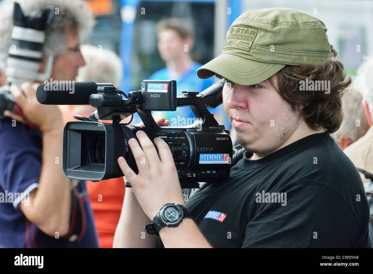 El sobrepeso camarógrafo alemán de la emisora regional Stimme.TV dispara con semi profesional cámara de vídeo HDV de Sony Foto de stock