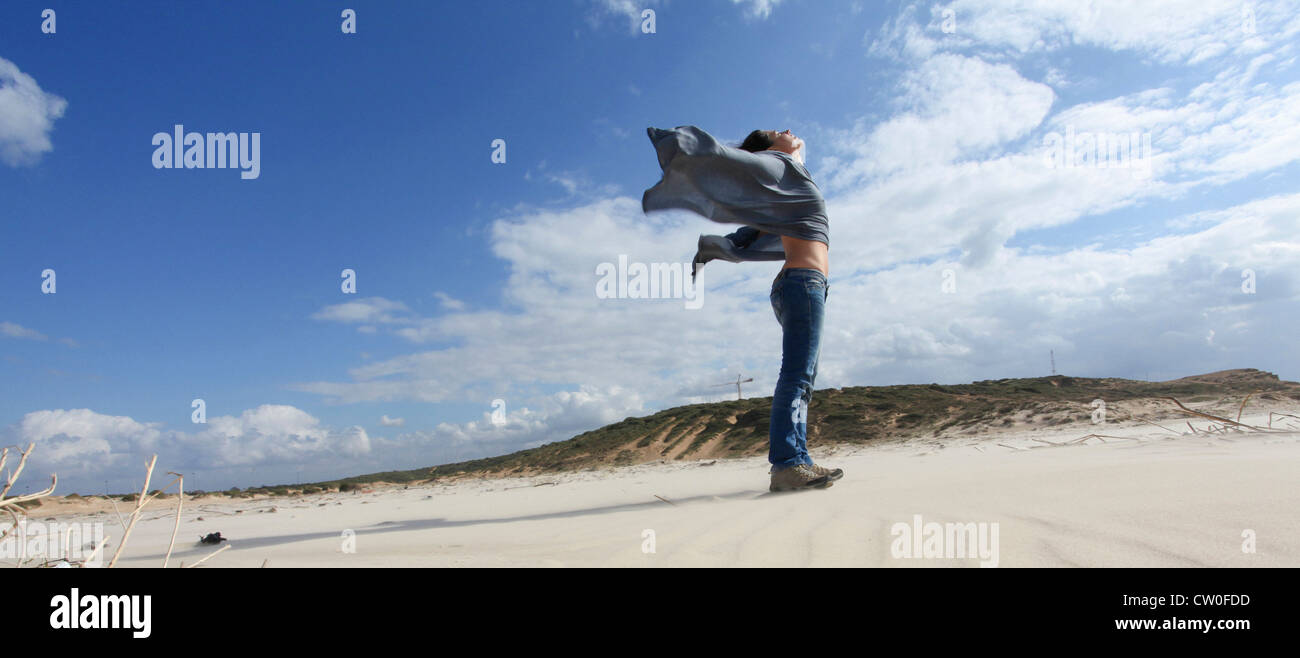 Mujer de pie en la playa ventosa Foto de stock