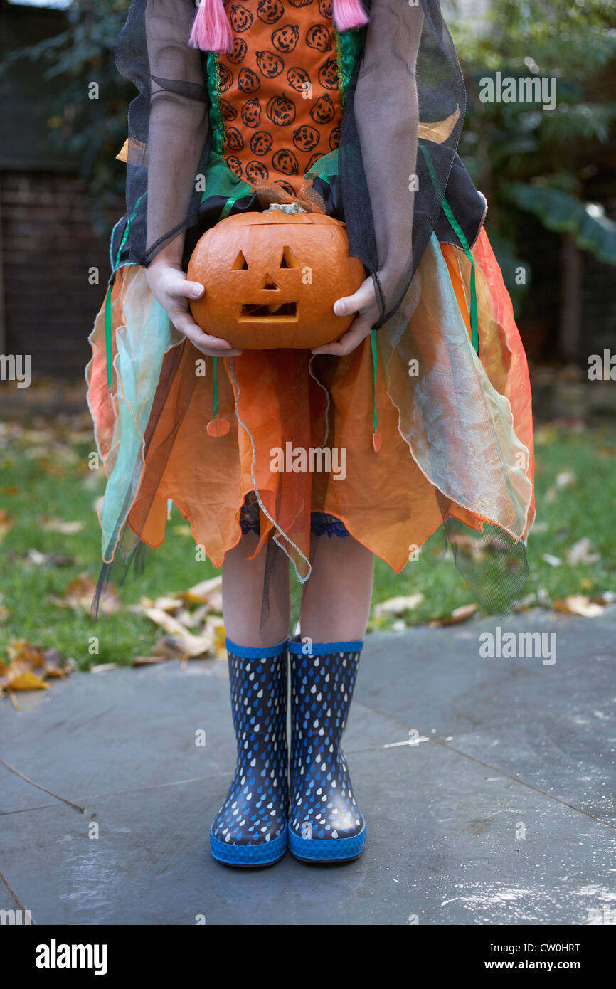 Chica en traje de Halloween con calabaza Foto de stock