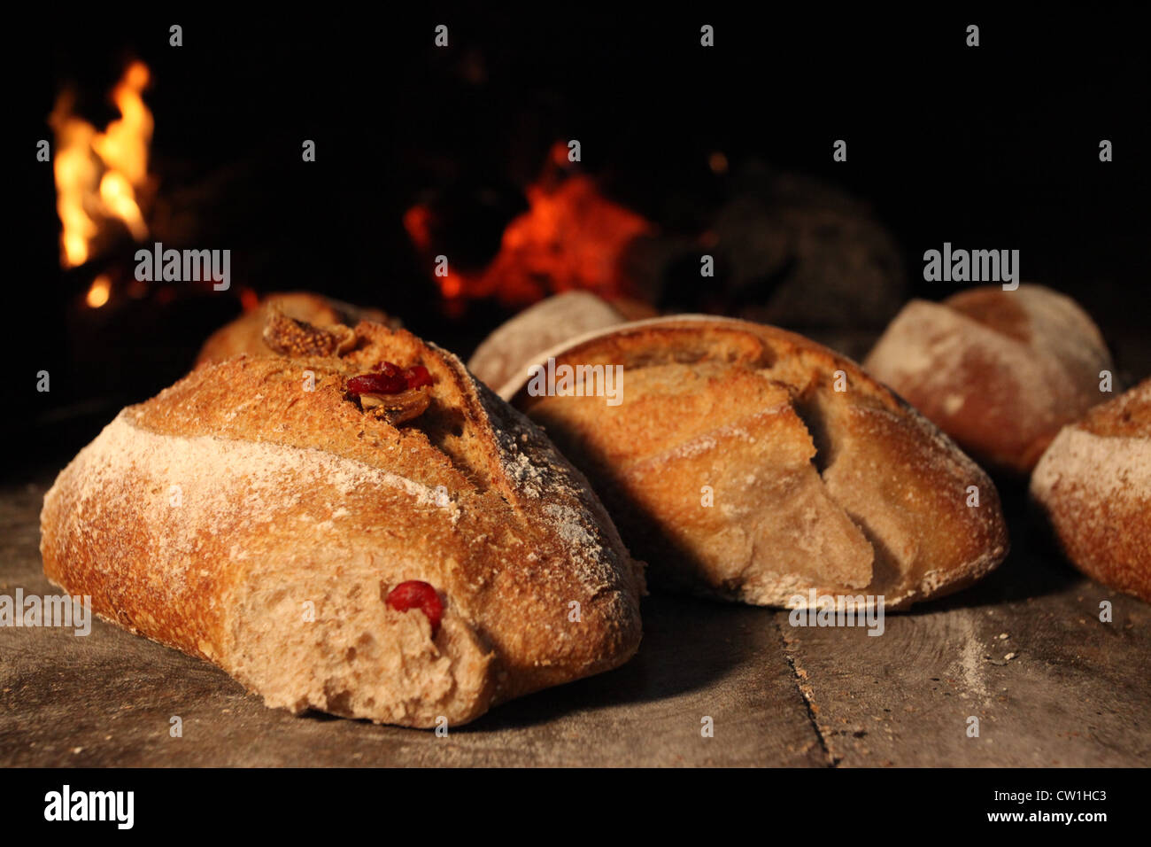 Pan recién horneado en un horno de piedra. Las llamas en el fondo  Fotografía de stock - Alamy