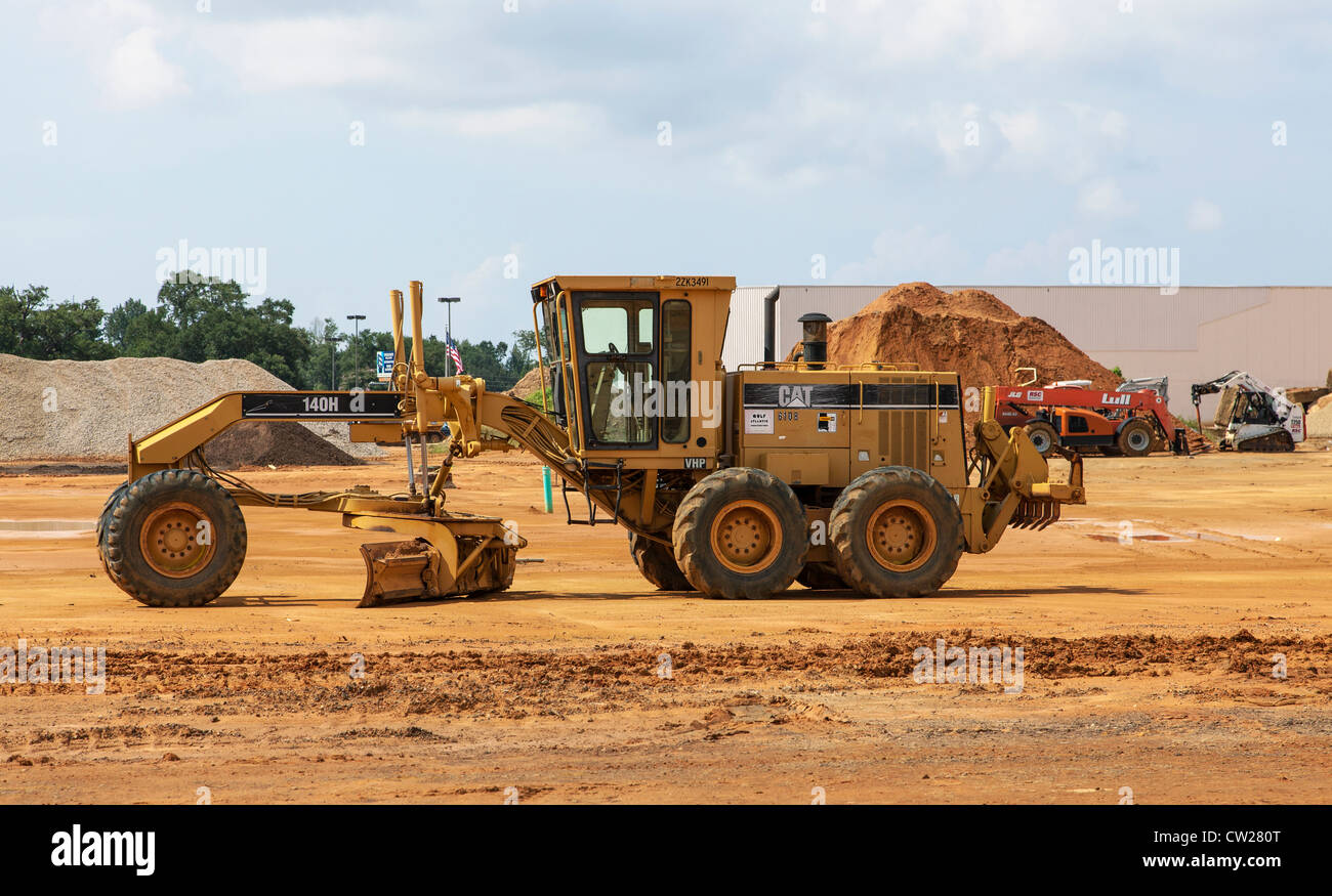 Motoniveladora Caterpillar 140H y otros equipos de movimiento de tierra pesado en mall sitio en construcción Foto de stock