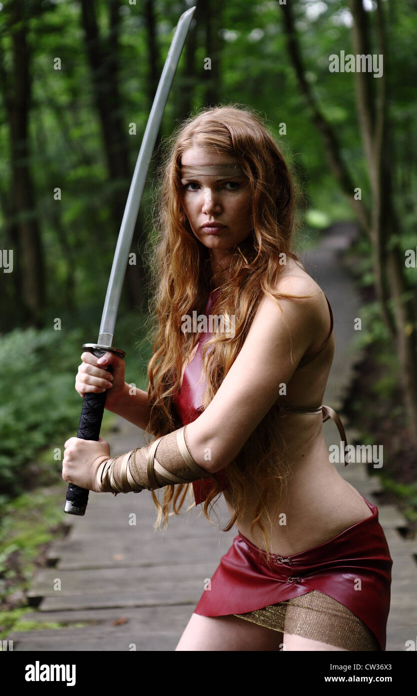 Retrato de mujer joven con la espada en el bosque Foto de stock