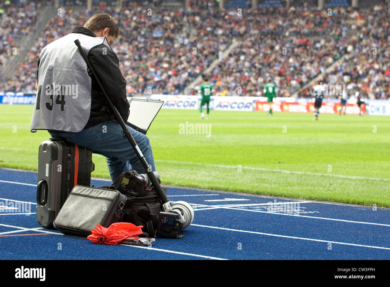 Berlín, un periodista deportivo, en un partido de fútbol en el banquillo Foto de stock