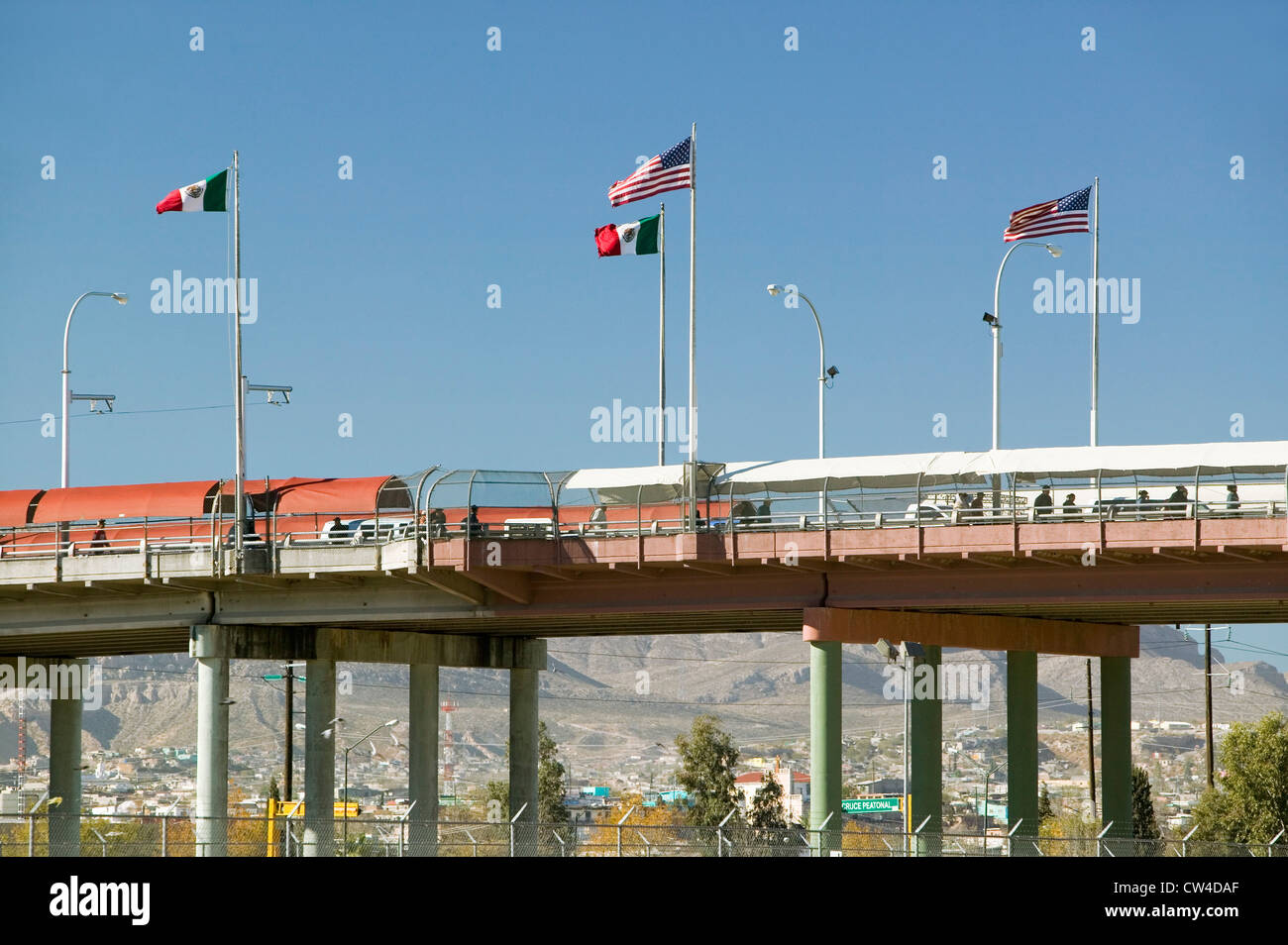 Frontera internacional entre México y los Estados Unidos, con banderas y el puente peatonal que