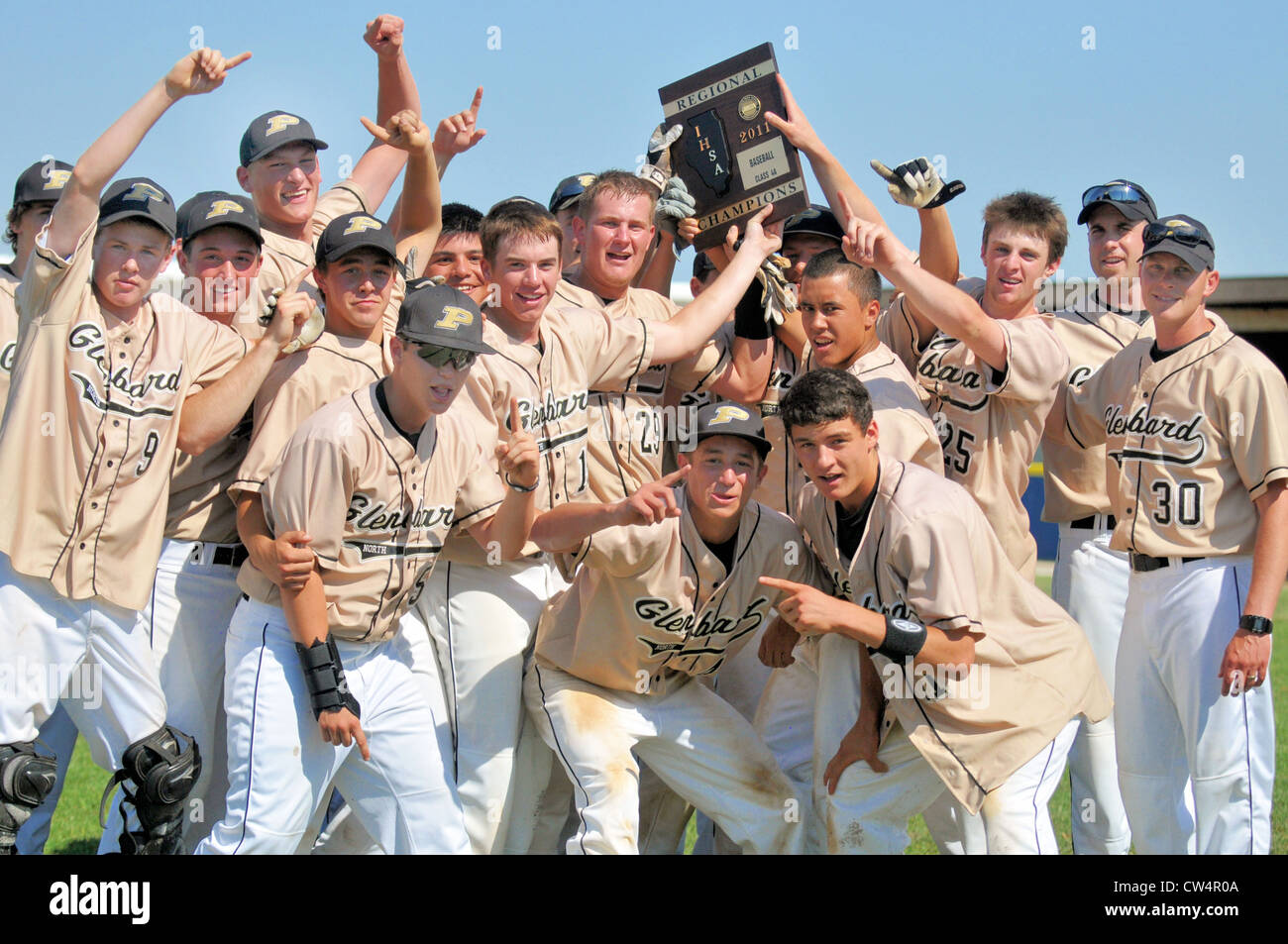 Equipo de béisbol celebra alrededor de su símbolo de ganar un campeonato regional high school juego del playoff. Ee.Uu.. Foto de stock