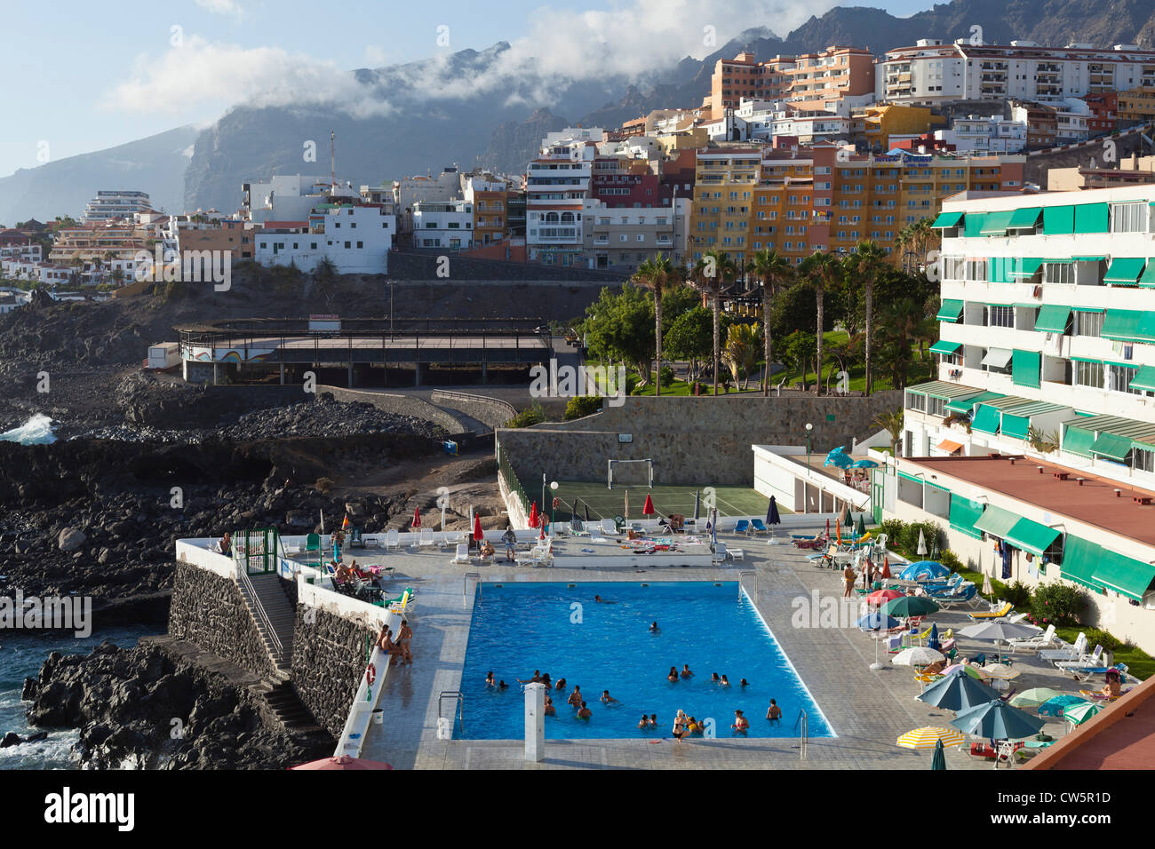 Bloque de apartamentos y piscina en la costa de Puerto Santiago debajo de  los acantilados de Los Gigantes en Tenerife, Islas Canarias Fotografía de  stock - Alamy