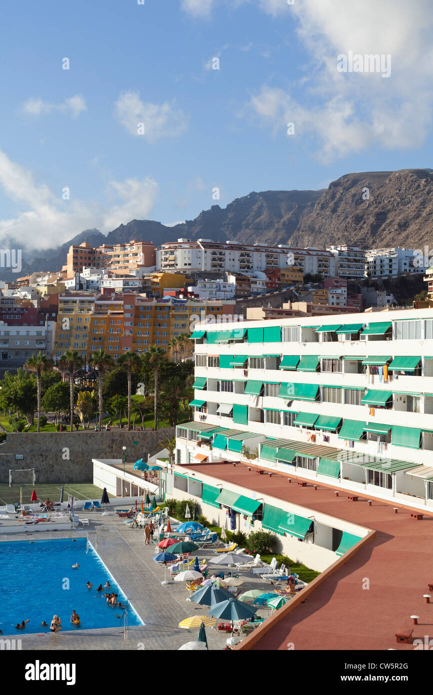 Bloque de apartamentos y piscina en la costa de Puerto Santiago debajo de  los acantilados de Los Gigantes en Tenerife, Islas Canarias Fotografía de  stock - Alamy