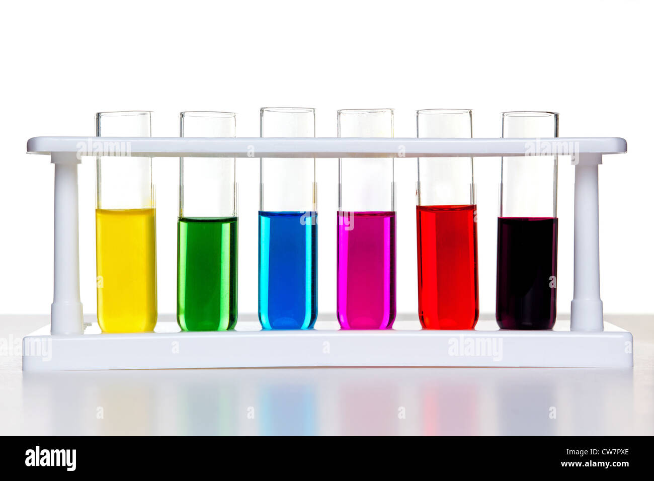 Foto de tubos de ensayo llenos de productos químicos en un bastidor sobre un fondo blanco. Foto de stock