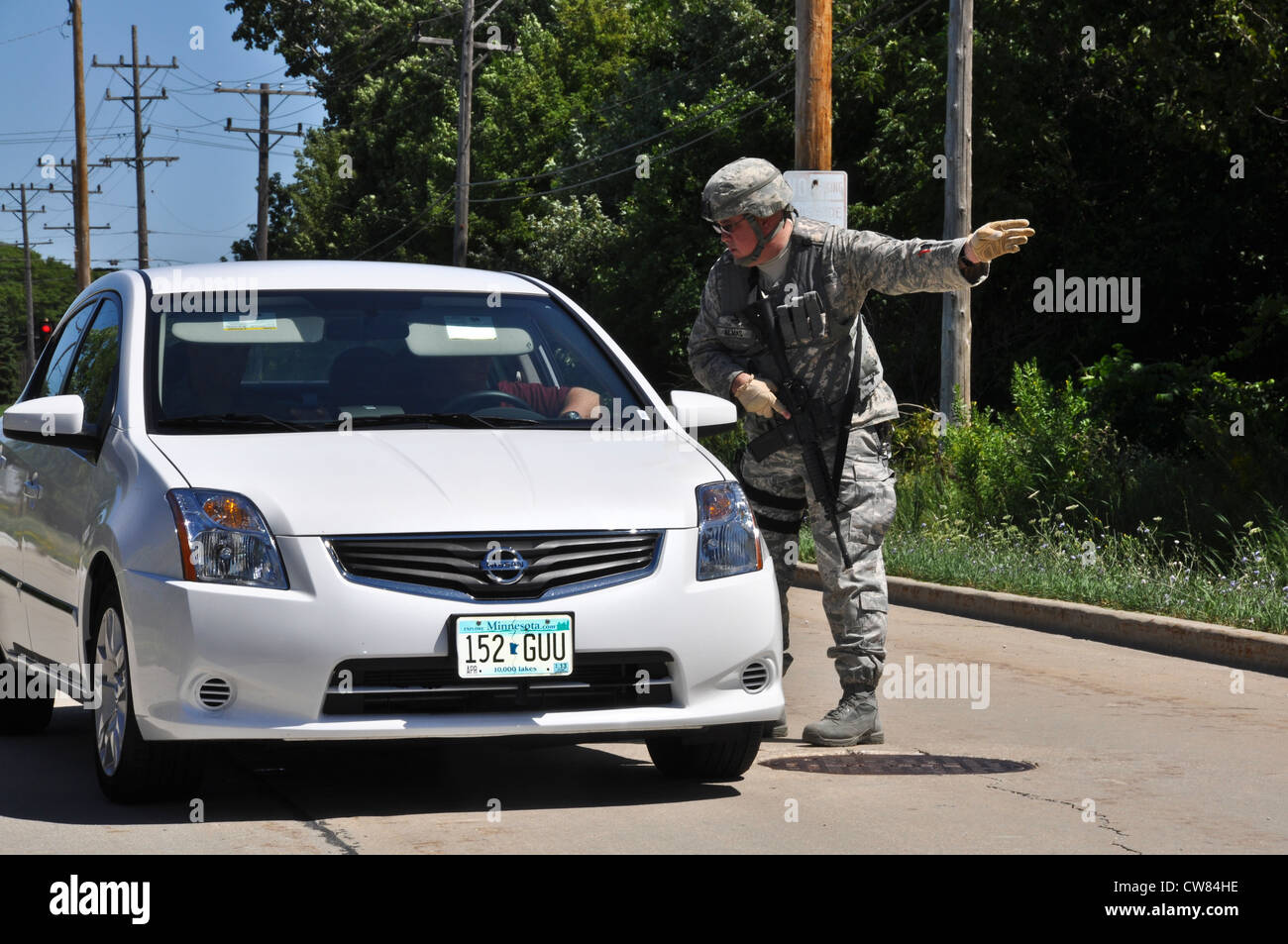 Personal Sgt. Harold almas de la 128th Air Reabasting Wing Security Forces, Milwaukee dirige un vehículo civil al lugar de espera apropiado después de un disparo fatal en el cercano templo de Sikh, el 5 de agosto de 2012. El ARW de 128 entró en encierro, un período de tiempo en que no se permitió que el personal entrara o salara de la base para garantizar la máxima seguridad. Foto de stock