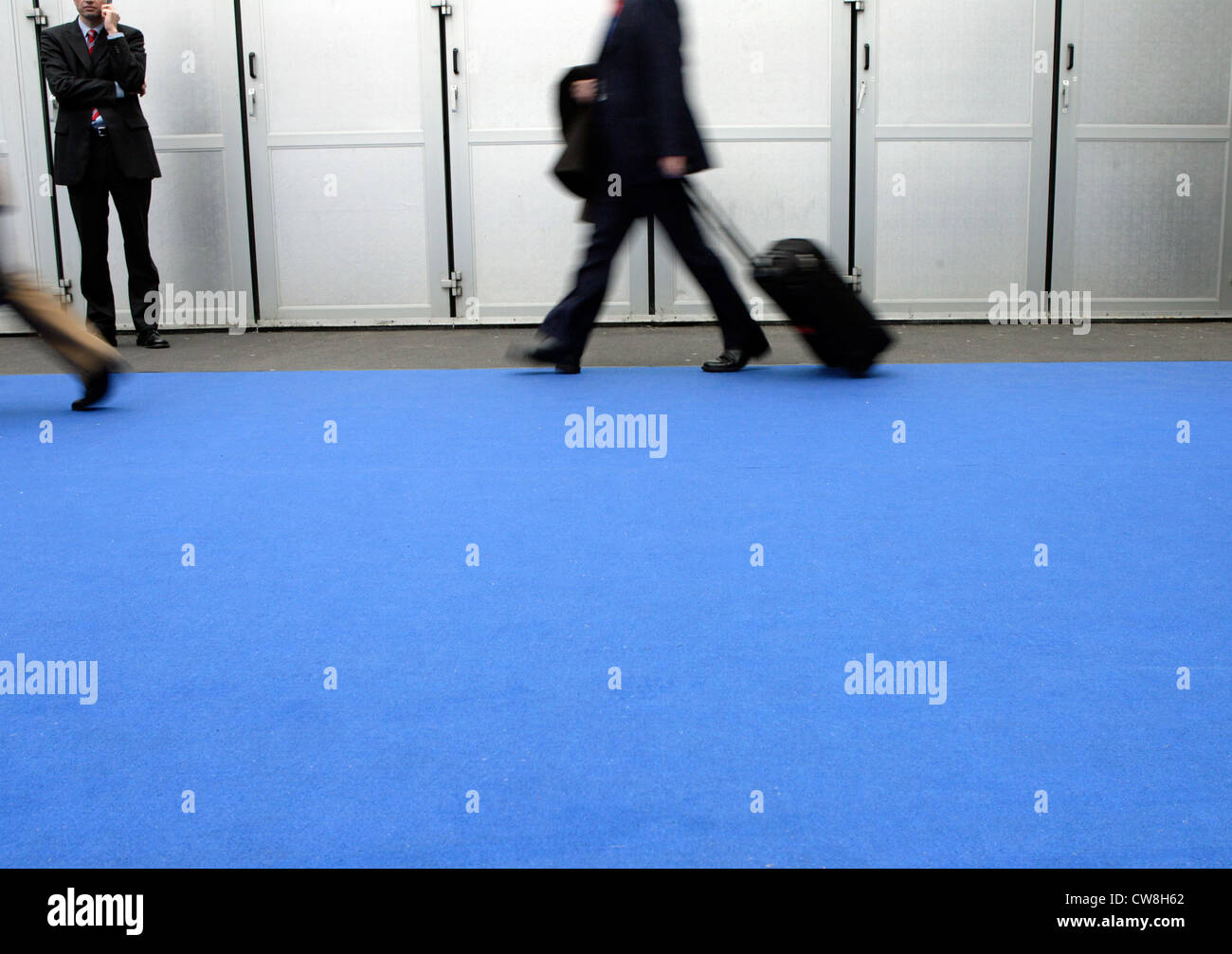 La gente de negocios de caminar sobre una alfombra azul Foto de stock