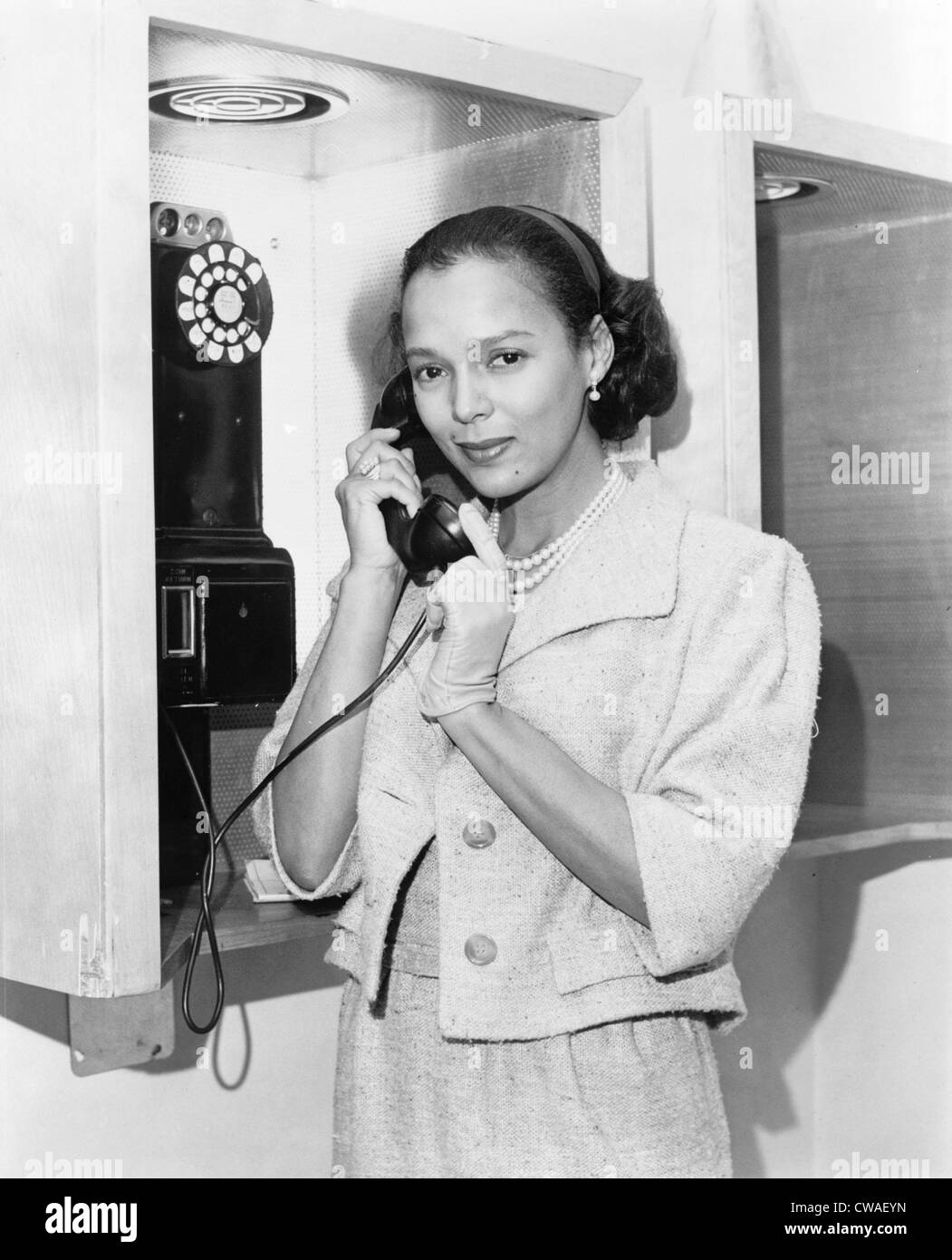 Dorothy Dandridge (1922-1965), retrato de longitud media, de pie, mirando hacia la izquierda, sosteniendo receptor telefónico en Nueva York del aeropuerto en Foto de stock