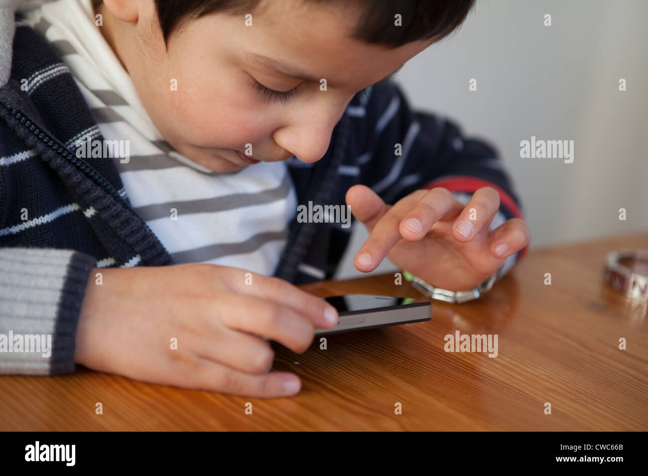 Boy,4 años ,juega con un teléfono inteligente. Foto de stock