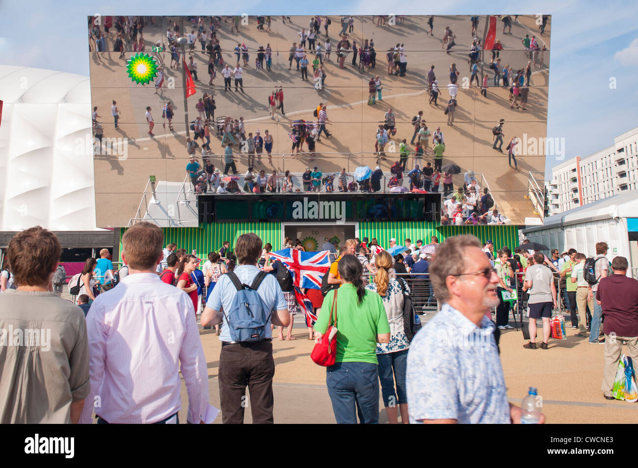 El Parque Olímpico de Stratford de Londres 2012 Multitudes de personas por BP alimentando el futuro espejo gigante & display bandera Union Jack hall Foto de stock