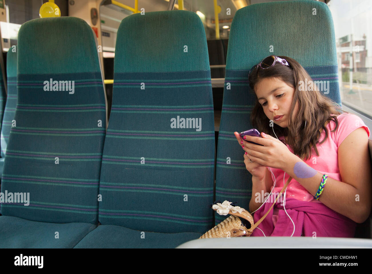 Niña escucha música en el transporte público,Londres,Inglaterra Foto de stock