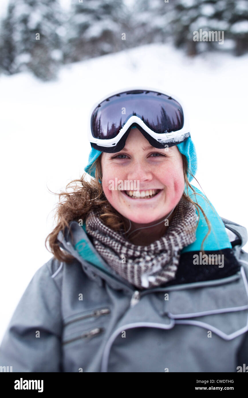 Una mujer joven feliz sonríe mientras toma un salto de esquí en Idaho. Foto de stock