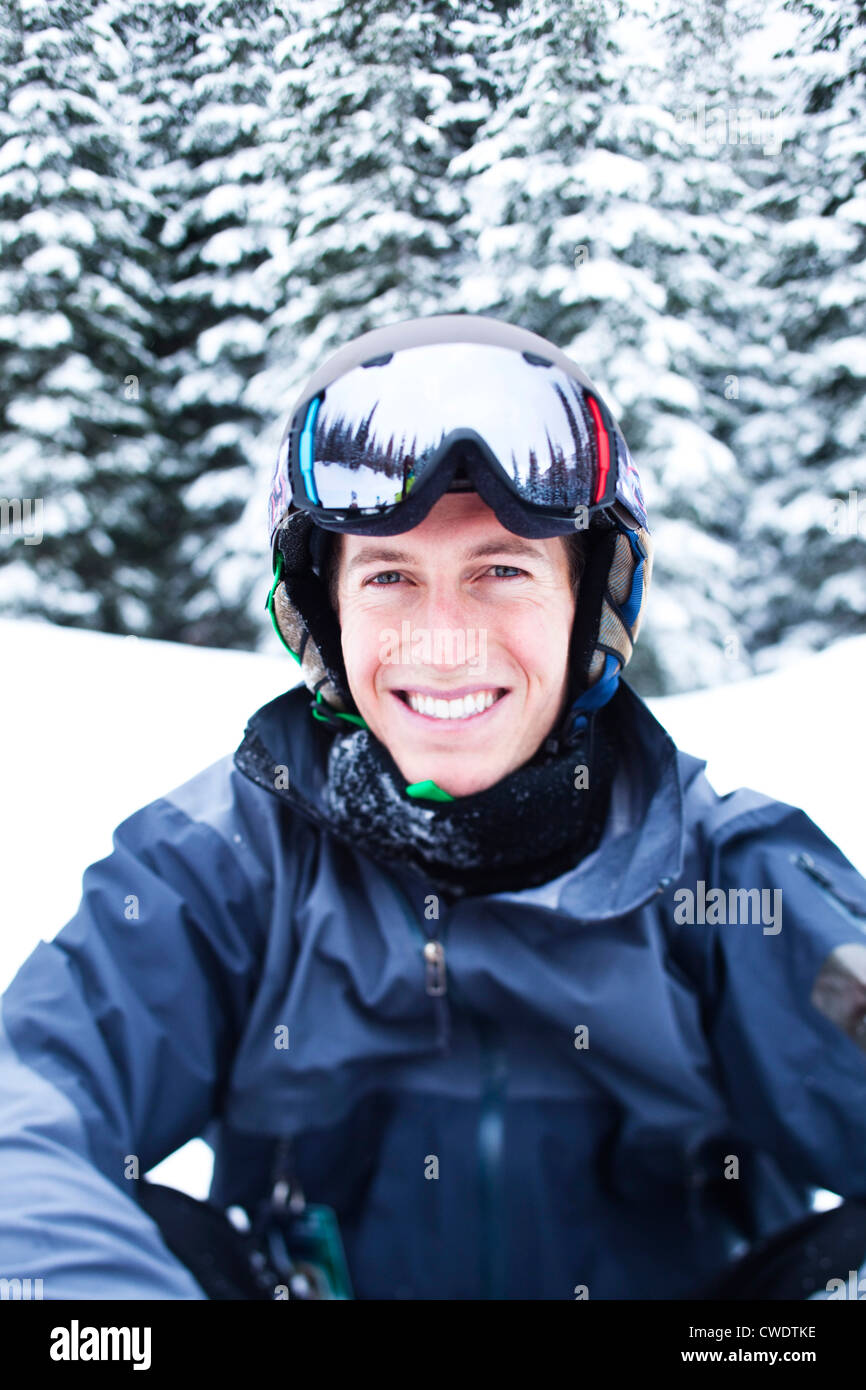 Un feliz joven sonríe mientras toma un salto de esquí en Idaho. Foto de stock