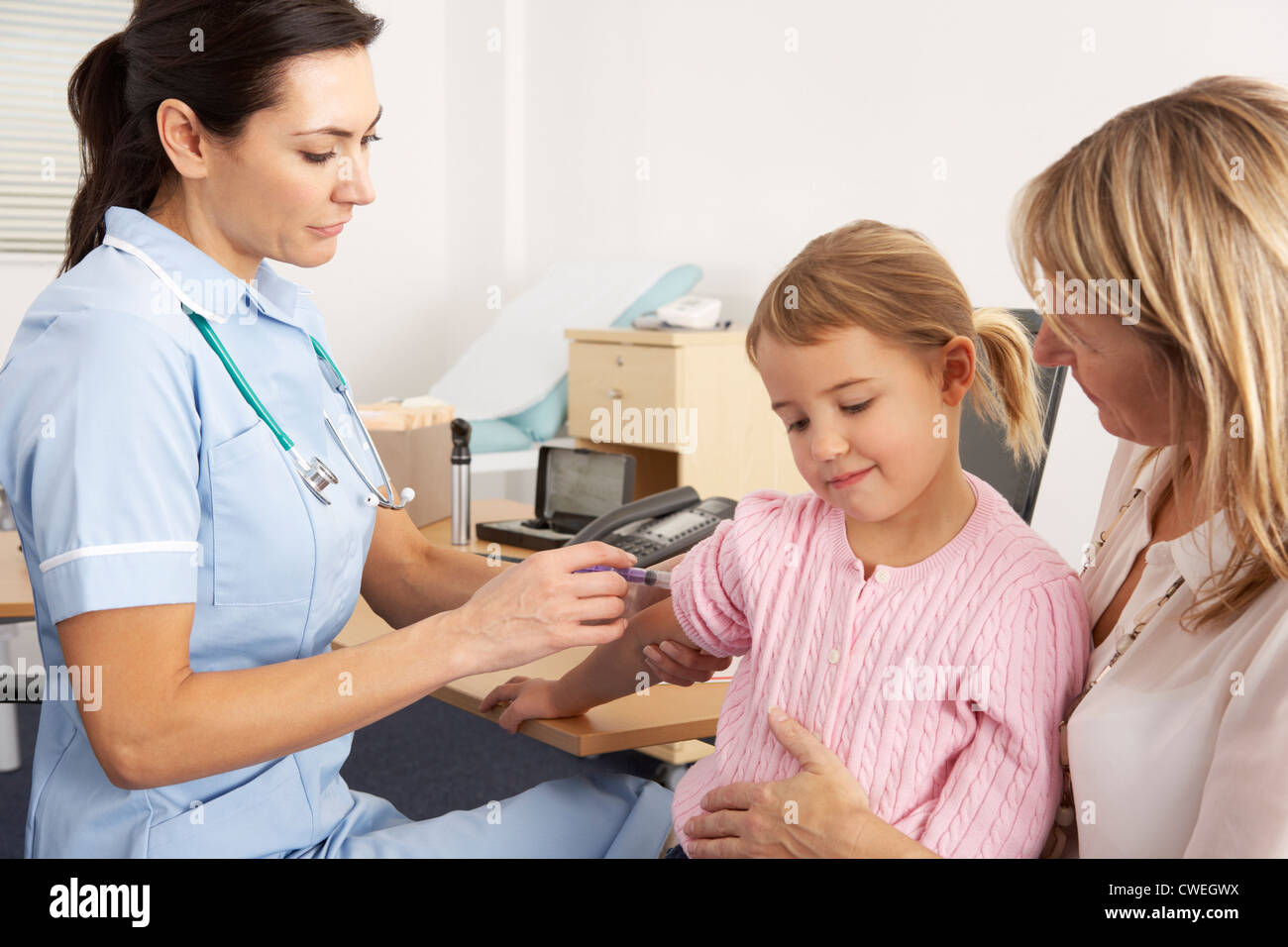 Enfermera británica dando inyección para niños pequeños Foto de stock