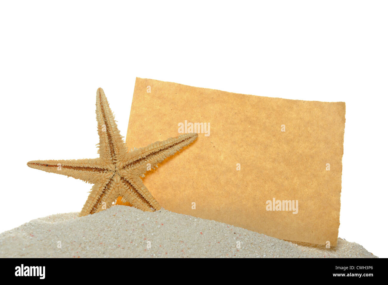 Starfish y papel antiguo en la arena aislado en blanco Foto de stock