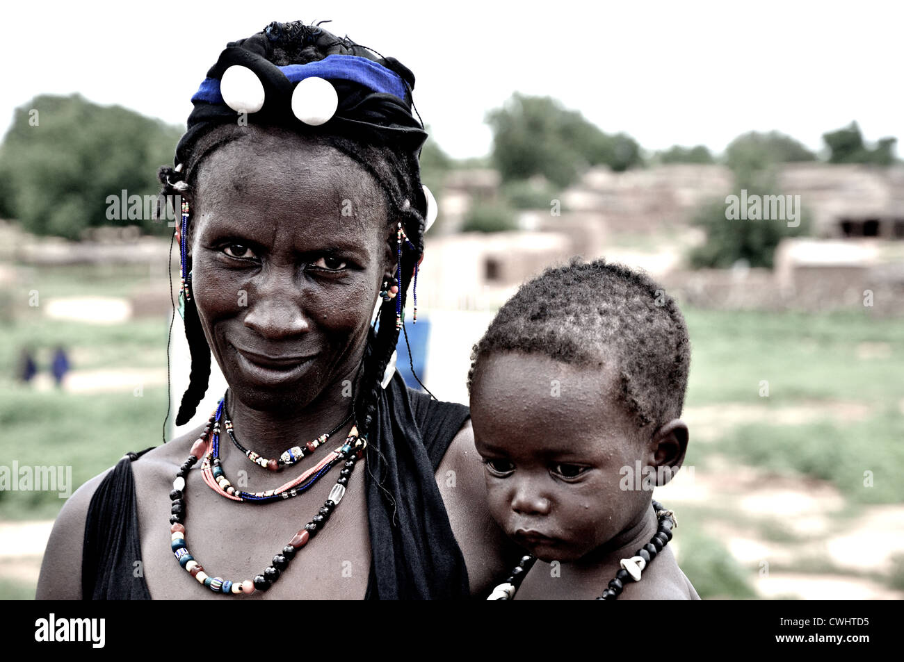 Peul mujer vistiendo joyería artesanal con su bebé, Malí Foto de stock