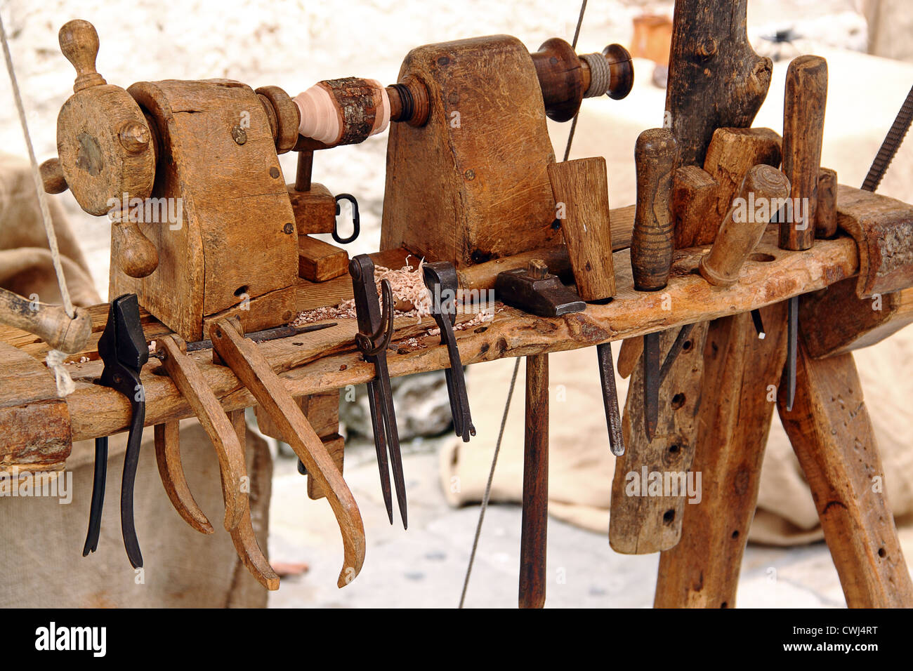 Un viejo torno con un conjunto de herramientas para trabajar la madera: martillo, cinceles, alicates Foto de stock
