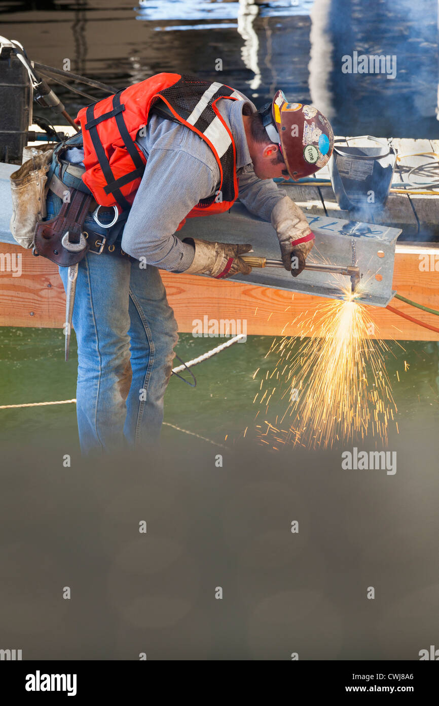 Trabajador caucásico soldadura en sitio en construcción Foto de stock