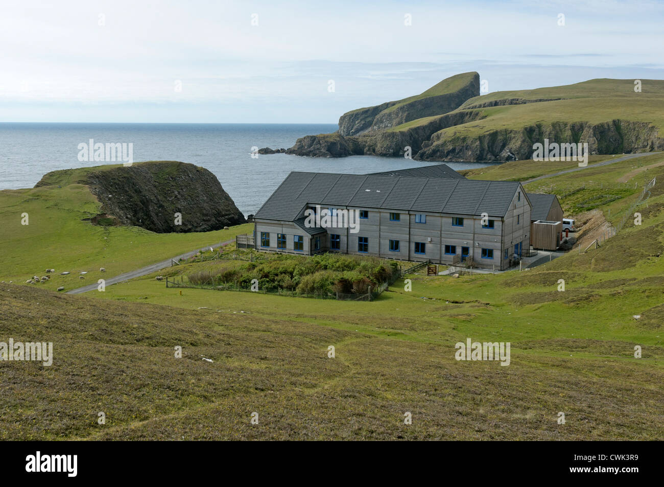 Fair Isle observatorio de aves en las Islas Shetland con ovejas Rock en segundo plano. De junio de 2012. Foto de stock