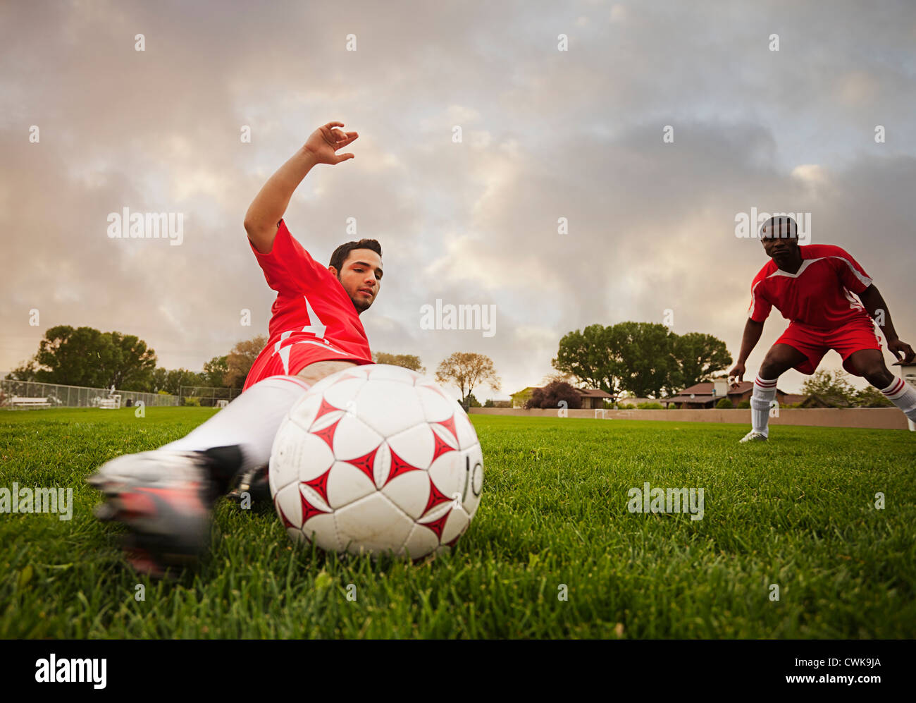 Jugador de fútbol Hispano pateando la pelota Foto de stock