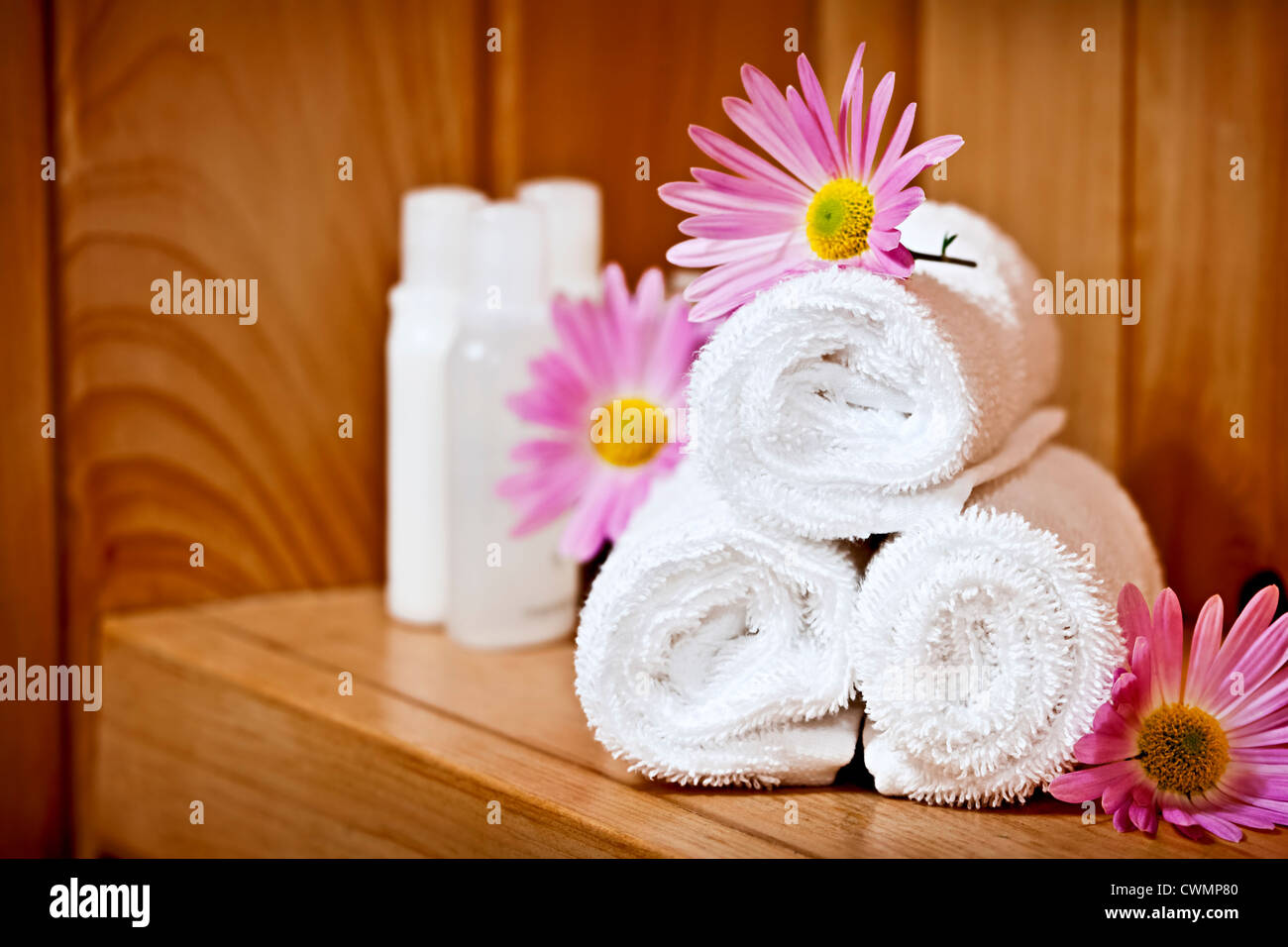 Laminada blanca hasta toallas de spa con productos para el cuidado del cuerpo Foto de stock