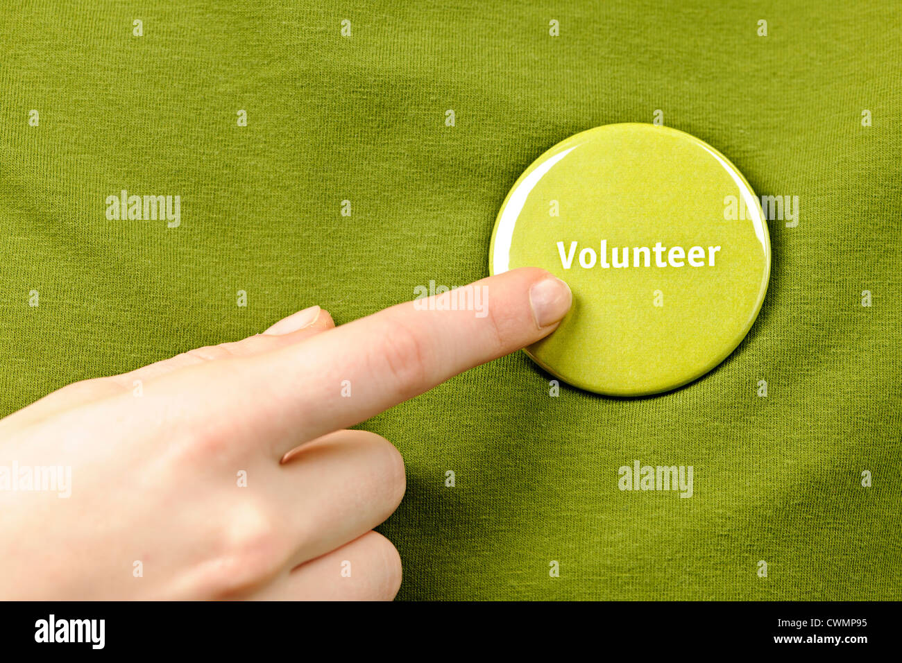 Señalar con el dedo a la Ronda verde botón de voluntariado Foto de stock