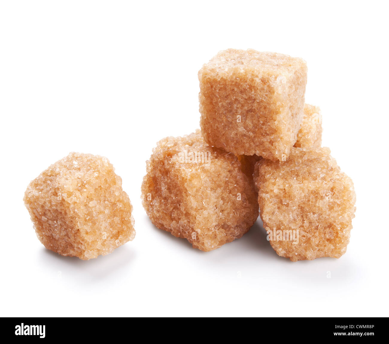 Cubos de azúcar marrón aislado sobre fondo blanco. Foto de stock