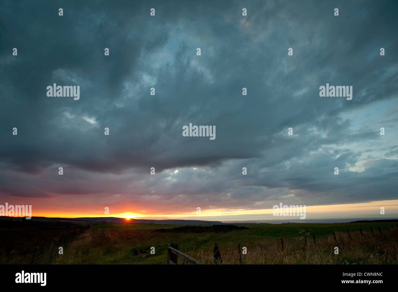 Puesta de sol y cielo sobre el dramático paisaje rural cerca de Whitby, North Yorkshire, Reino Unido Foto de stock