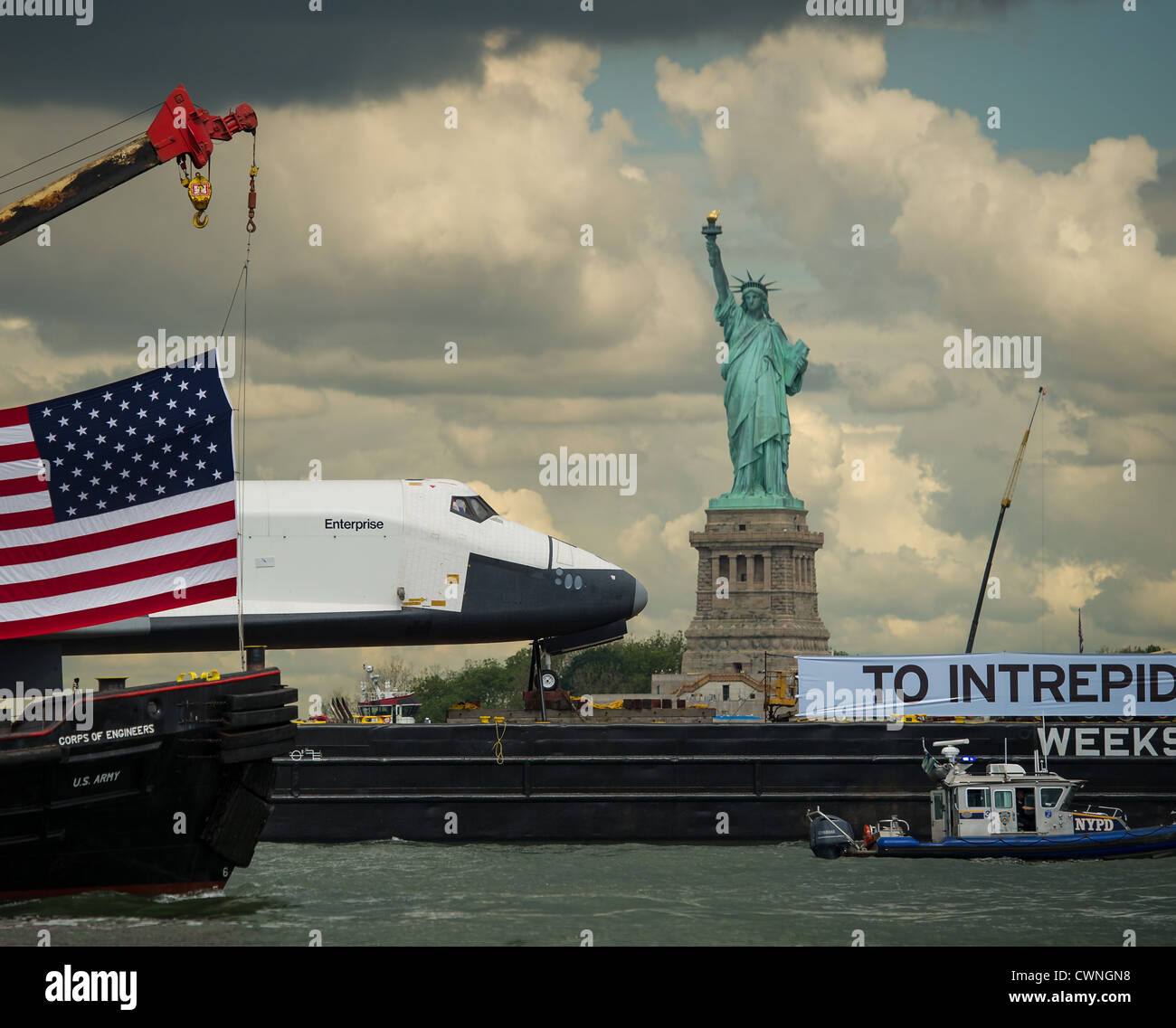 El transbordador espacial Enterprise, en la cima de una barcaza, pasa de la Estatua de la Libertad en Nueva York, en su camino a la intrépida Mar, Museo del Aire y el espacio, el 6 de junio de 2012. Foto de stock