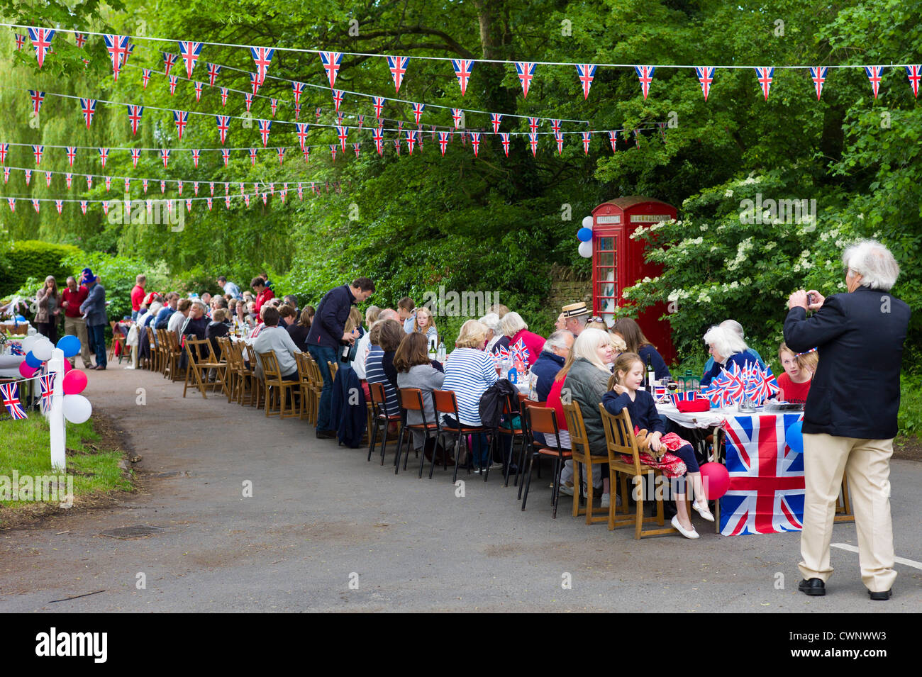 Fiesta en la calle con banderas de la Union Jack y bunting para celebrar el Queen's Diamond Jubilee en Swinbrook en Cotswolds, REINO UNIDO Foto de stock