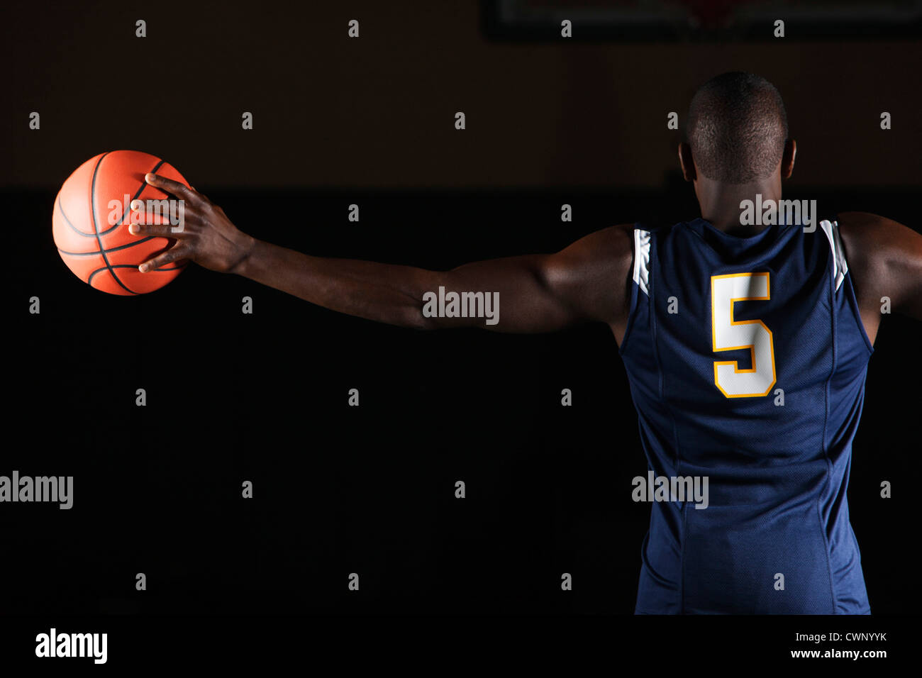 El jugador de baloncesto baloncesto sosteniendo en la mano, vista trasera Foto de stock