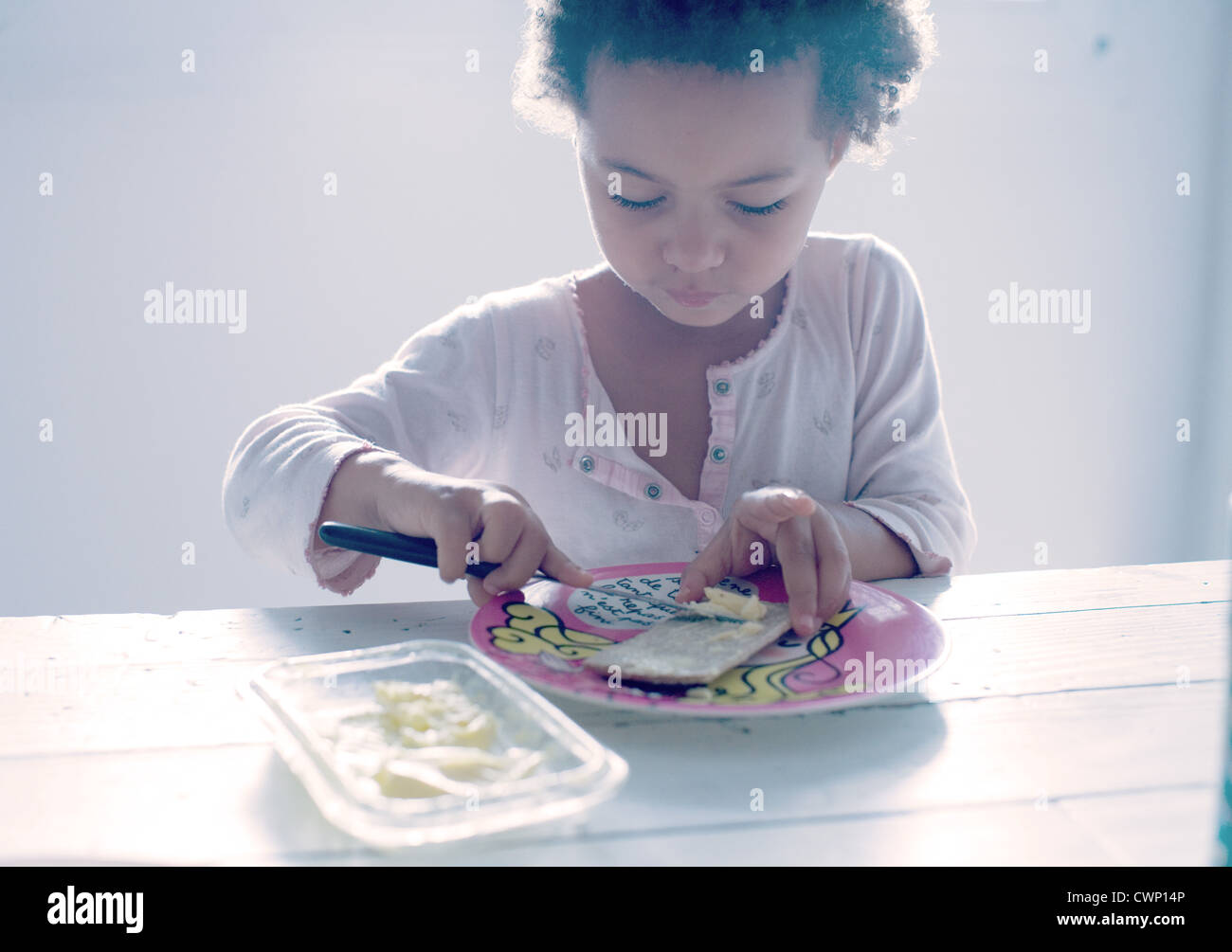 Niña preparando un snack Foto de stock